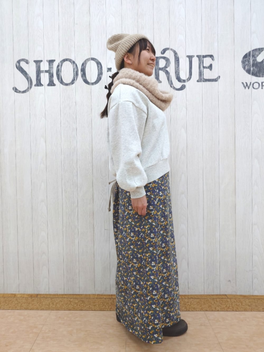 ホワイト系のスウェット、ブラウン系のショルダーバッグ、ブラウン系のブーツを着用したレディースの秋コーディネートの2枚目の写真