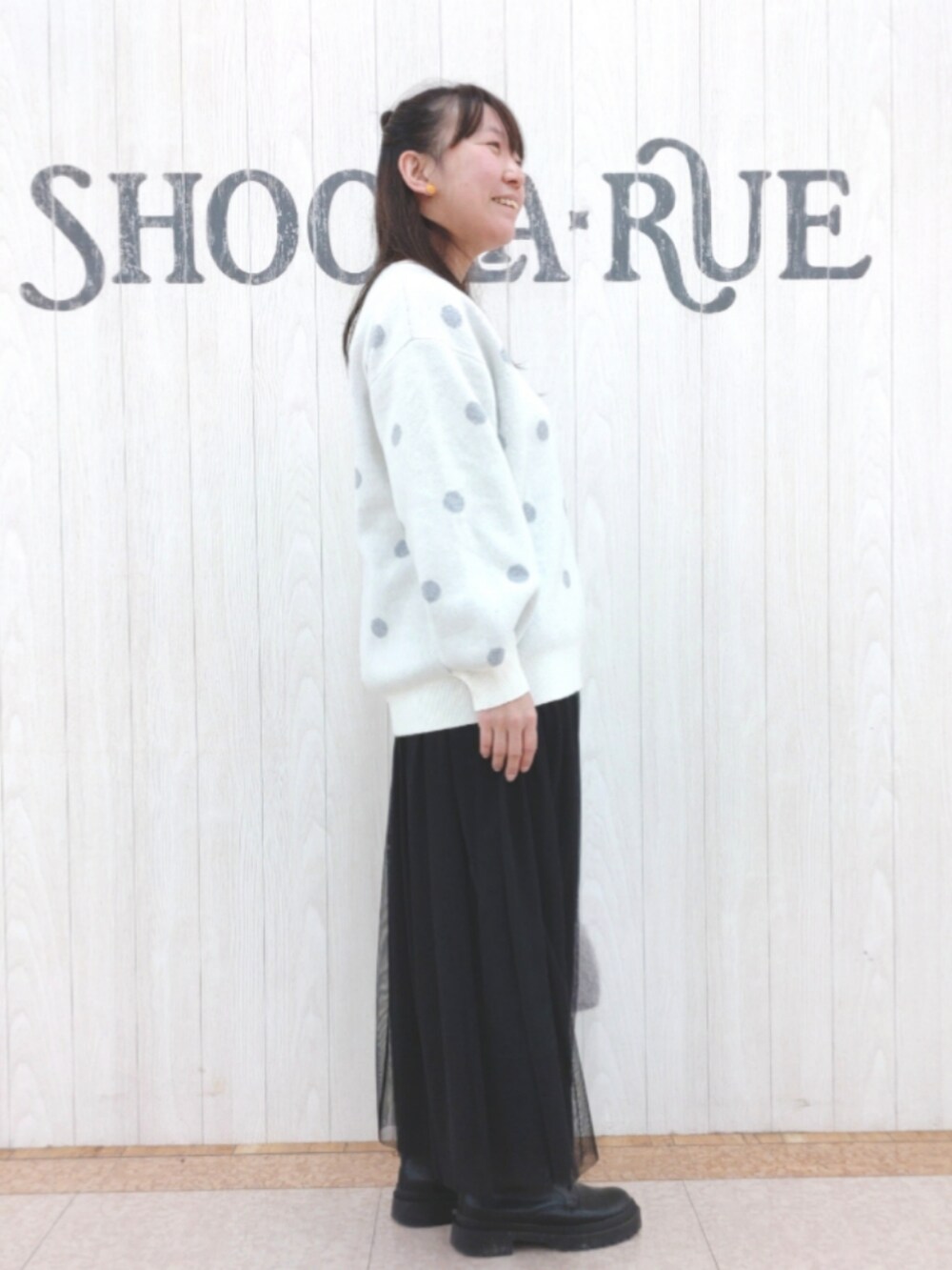 ホワイト系のニット/セーター、ベージュ系のショルダーバッグ、ブラック系のスカートを着用したレディースの冬コーディネートの2枚目の写真