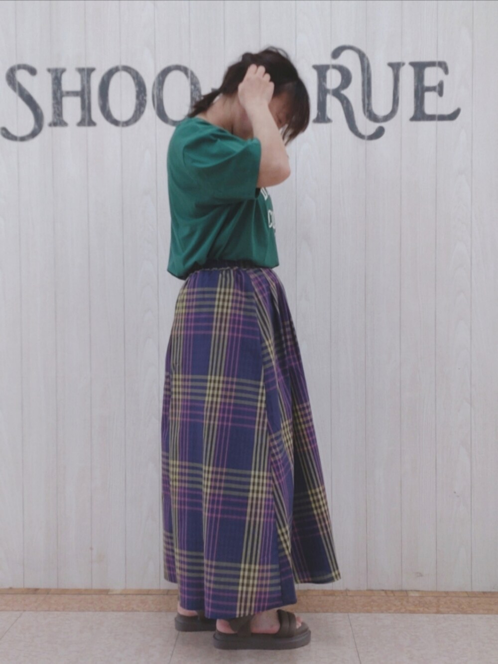 グリーン系のTシャツ/カットソー、グレー系のショルダーバッグ、ブルー系のスカートを着用したレディースの夏コーディネートの2枚目の写真