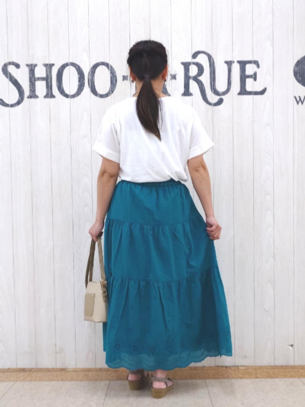 ホワイト系のTシャツ/カットソー、グリーン系のスカート、ベージュ系のショルダーバッグを着用したレディースの夏コーディネートの3枚目の写真