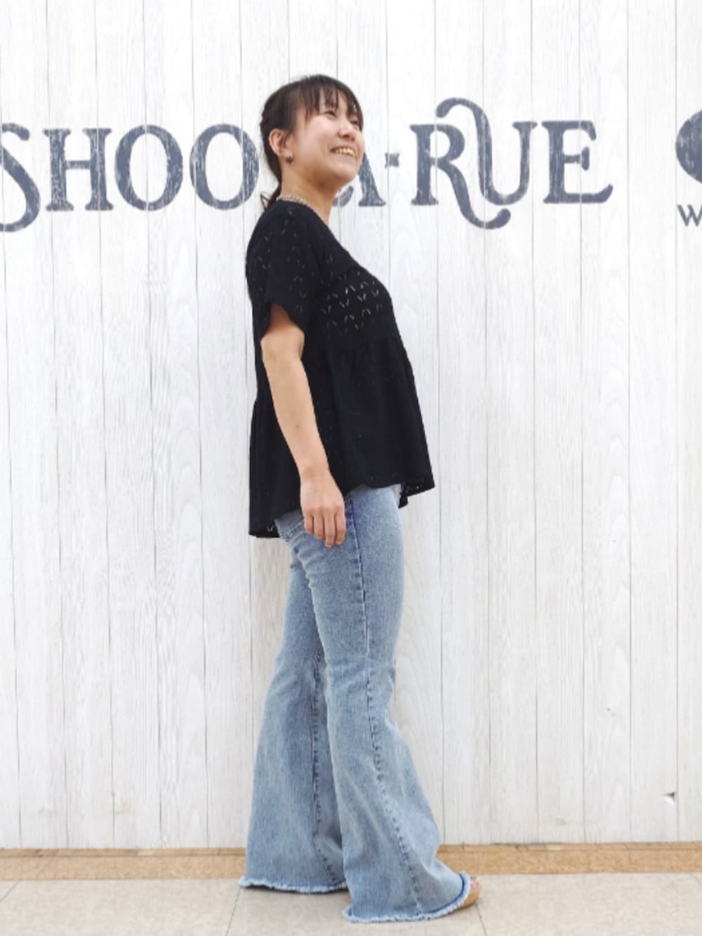 ブラック系のTシャツ/カットソー、ブルー系のデニムパンツ、ブラック系のショルダーバッグを着用したレディースの秋コーディネートの2枚目の写真