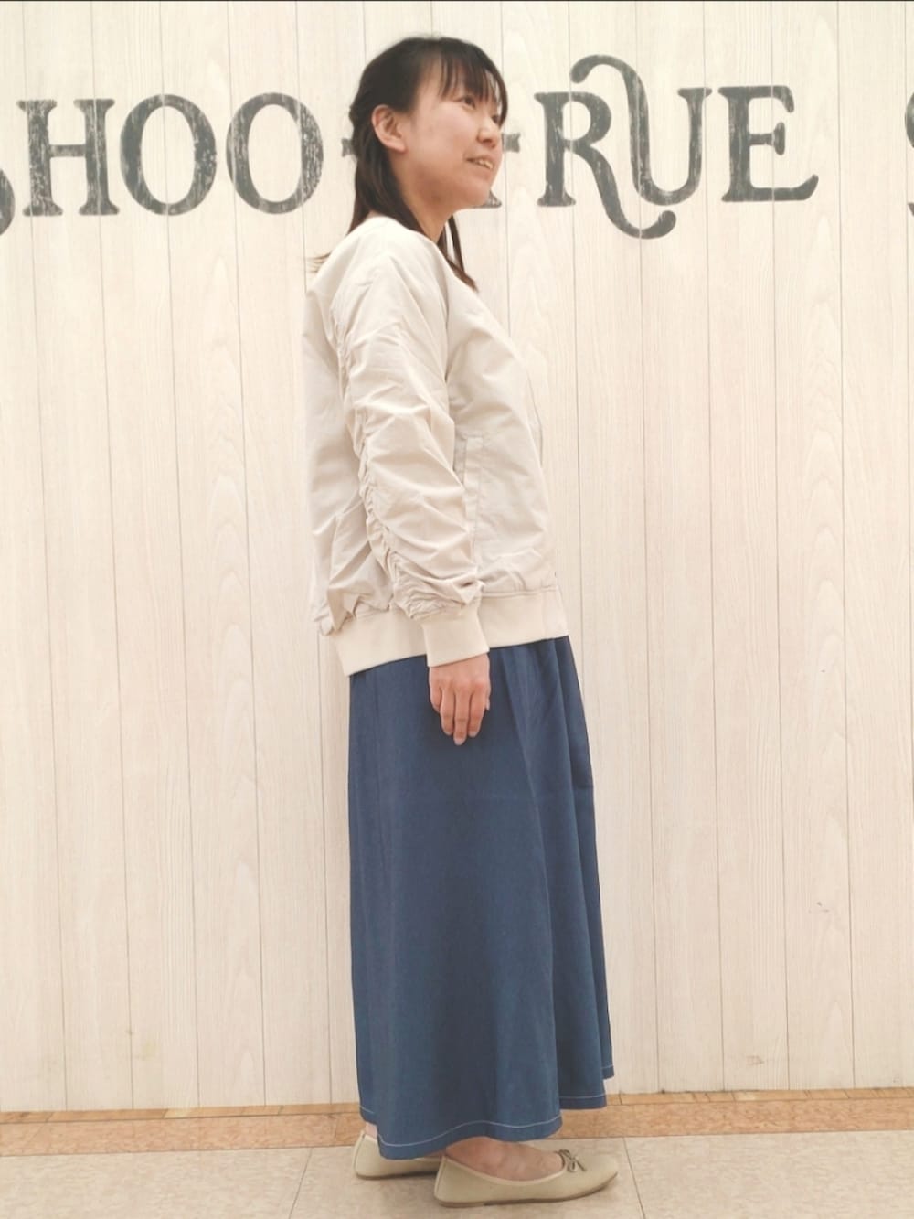 シルバー系のショルダーバッグ、ベージュ系のブルゾン、ホワイト系のTシャツ/カットソーを着用したレディースの春コーディネートの2枚目の写真