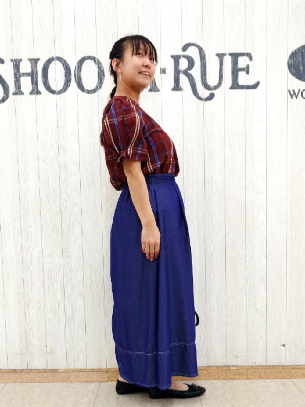 レッド系のシャツ/ブラウス、ブラック系のバックパック/リュック、ブルー系のスカートを着用したレディースの秋コーディネートの2枚目の写真