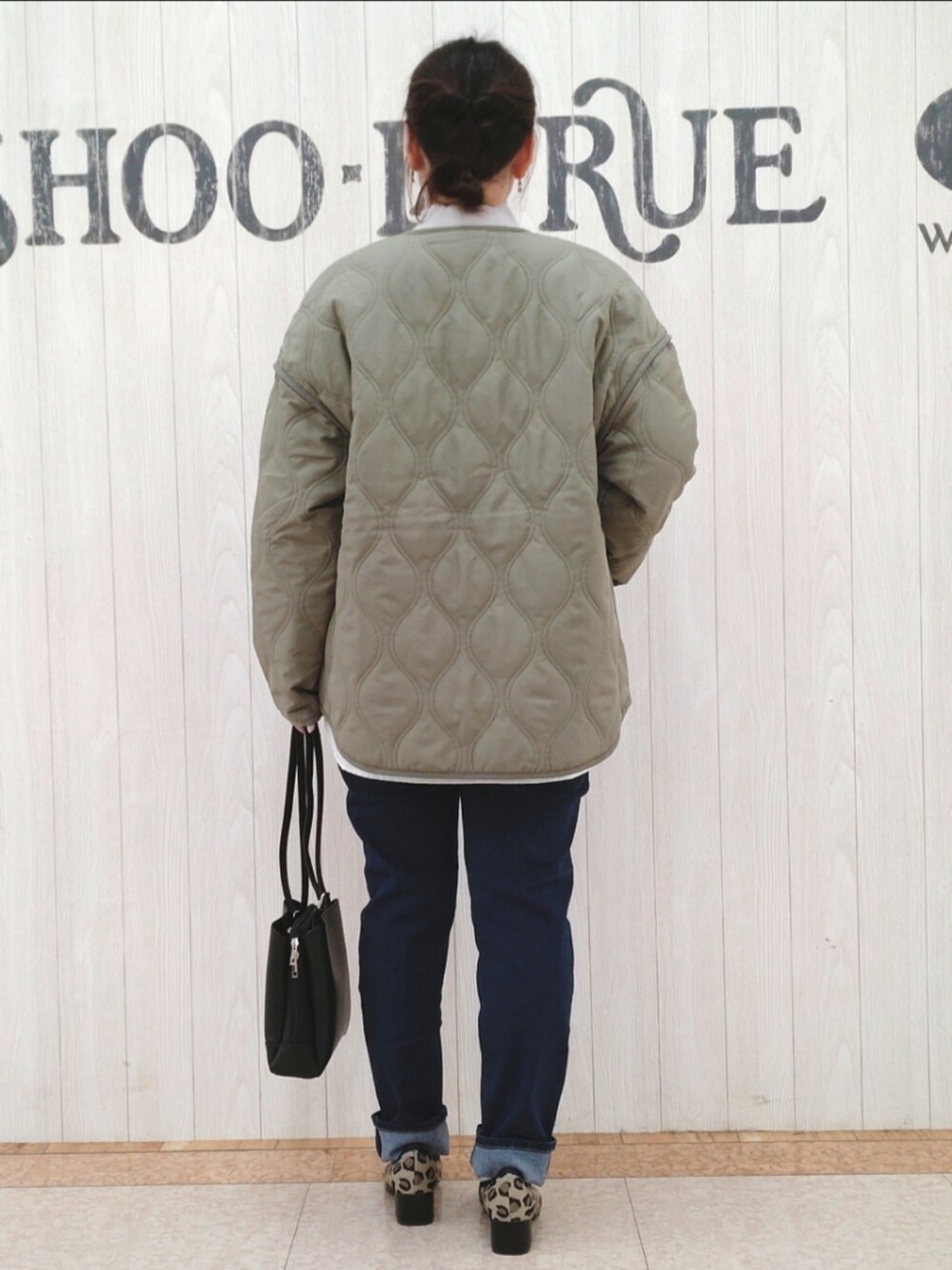 グレー系のニット/セーター、グリーン系のその他アウター、ブラック系のショルダーバッグを着用したレディースの春コーディネートの3枚目の写真