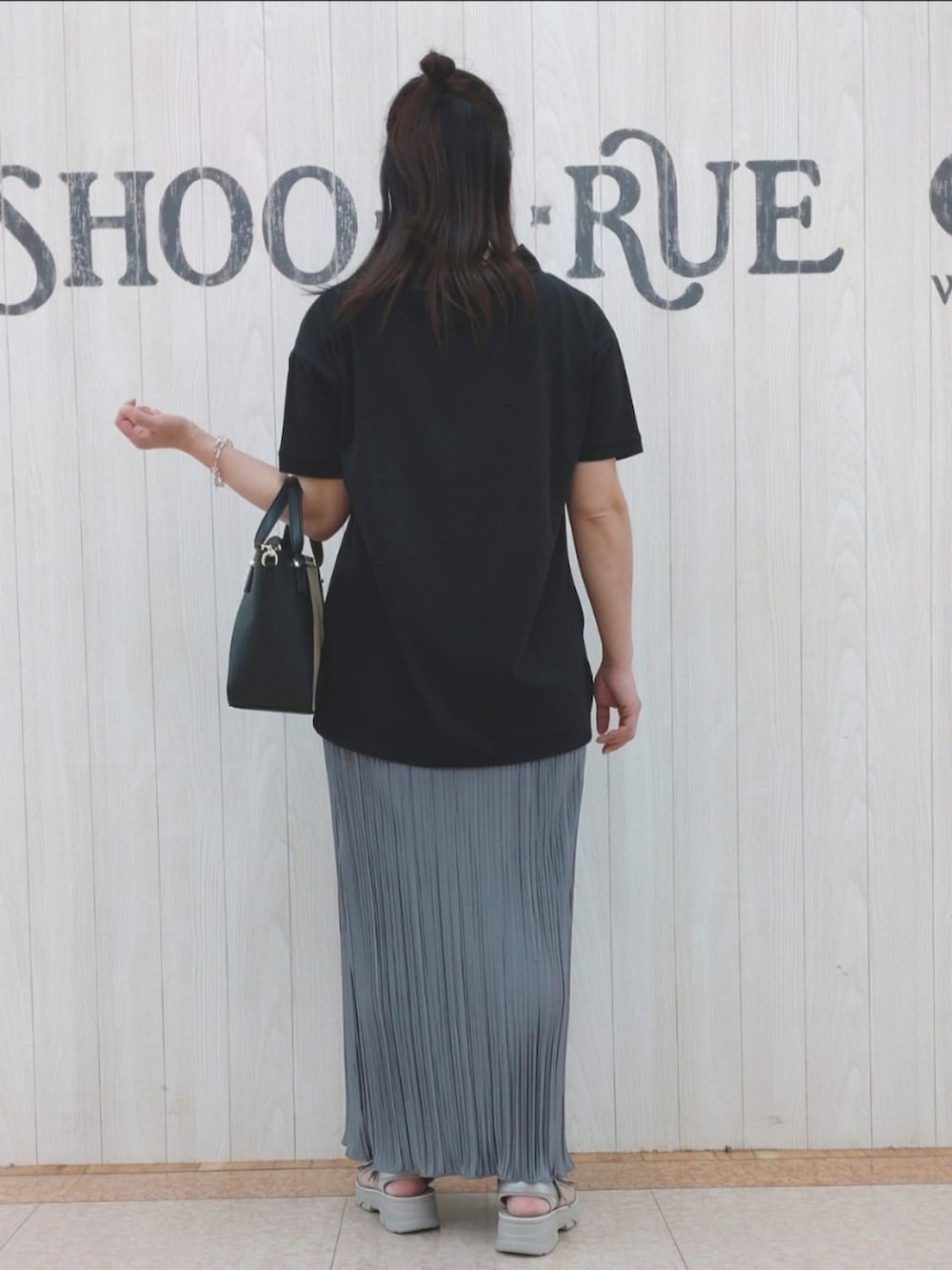 ブラック系のTシャツ/カットソー、ブラック系のトートバッグ、グレー系のスカートを着用したレディースの夏コーディネートの3枚目の写真