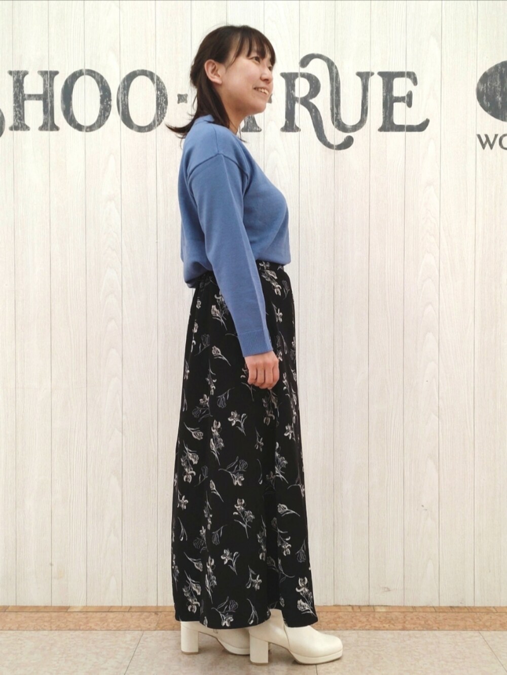 ブルー系のニット/セーター、ホワイト系のトートバッグ、ブラック系のスカートを着用したレディースの秋コーディネートの2枚目の写真