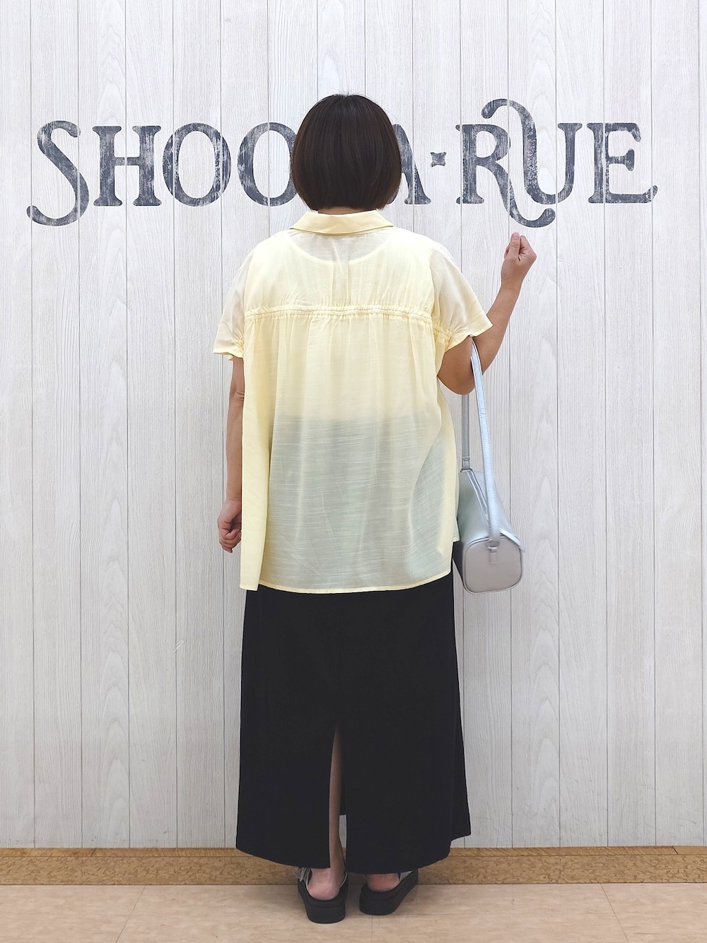 イエロー系のシャツ/ブラウス、ホワイト系のタンクトップ、ブラック系のスカートを着用したレディースの夏コーディネートの3枚目の写真