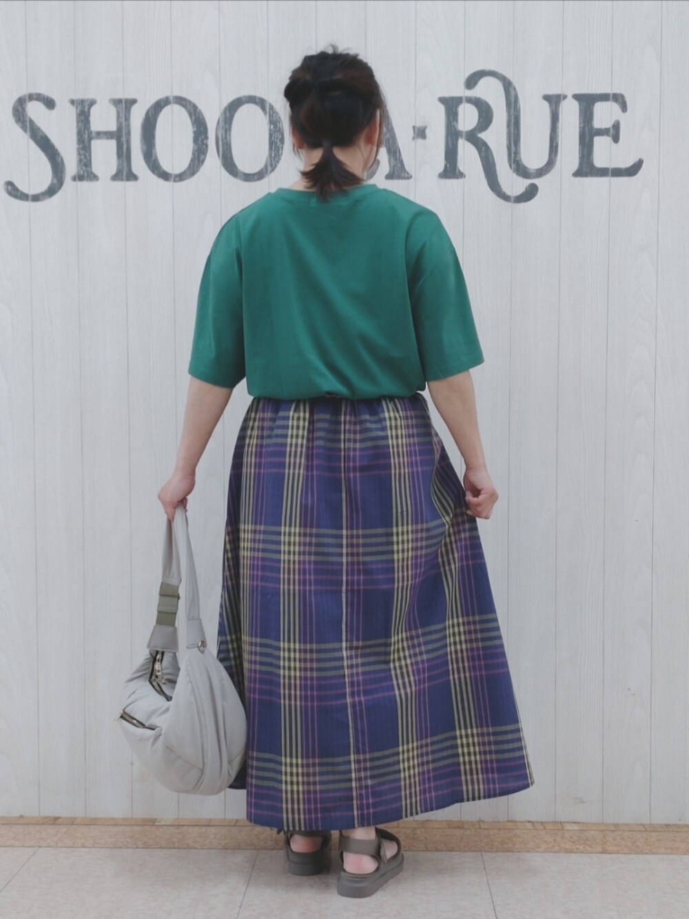 グリーン系のTシャツ/カットソー、グレー系のショルダーバッグ、ブルー系のスカートを着用したレディースの夏コーディネートの3枚目の写真