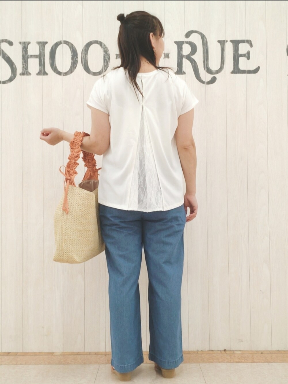 ホワイト系のTシャツ/カットソー、オレンジ系のショルダーバッグ、ブルー系のデニムパンツを着用したレディースの秋コーディネートの3枚目の写真