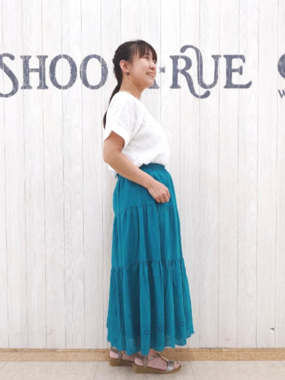 ホワイト系のTシャツ/カットソー、グリーン系のスカート、ベージュ系のショルダーバッグを着用したレディースの夏コーディネートの2枚目の写真