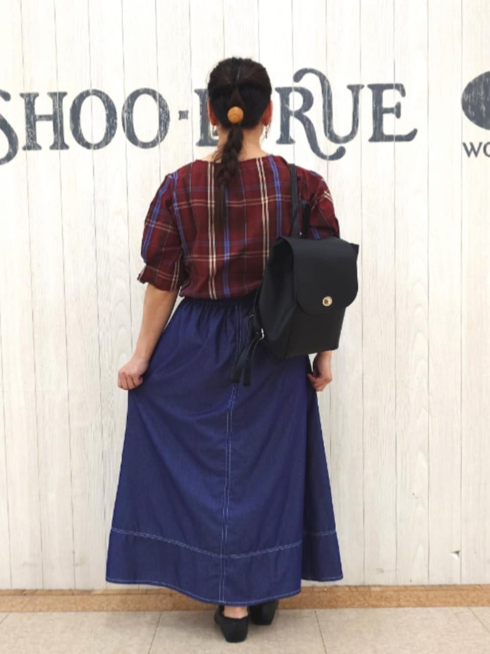 レッド系のシャツ/ブラウス、ブラック系のバックパック/リュック、ブルー系のスカートを着用したレディースの秋コーディネートの3枚目の写真