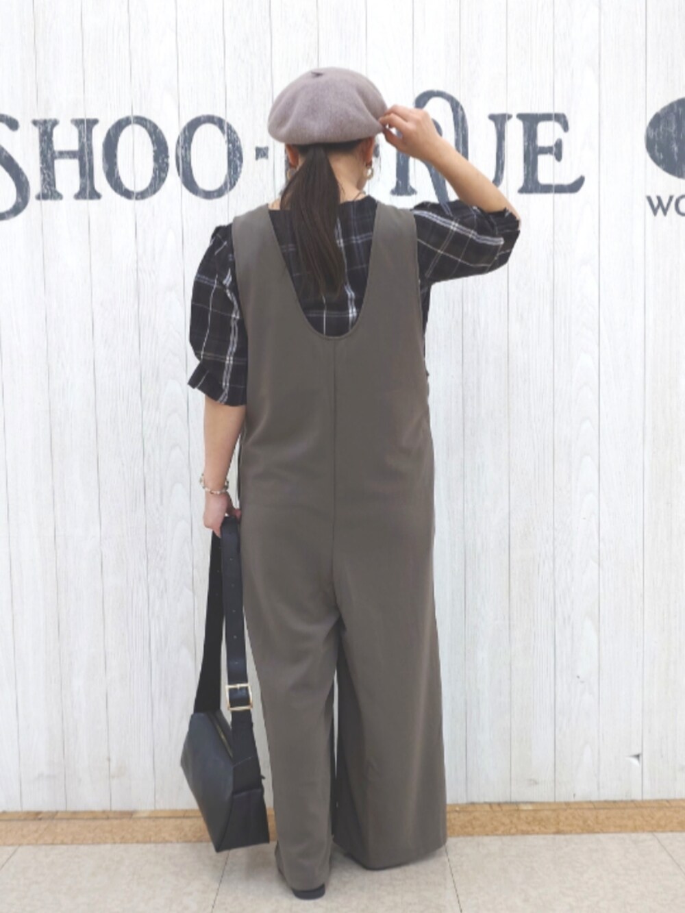 ブラウン系のサロペット/オーバーオール、ブラック系のシャツ/ブラウス、ブラック系のショルダーバッグを着用したレディースの秋コーディネートの3枚目の写真