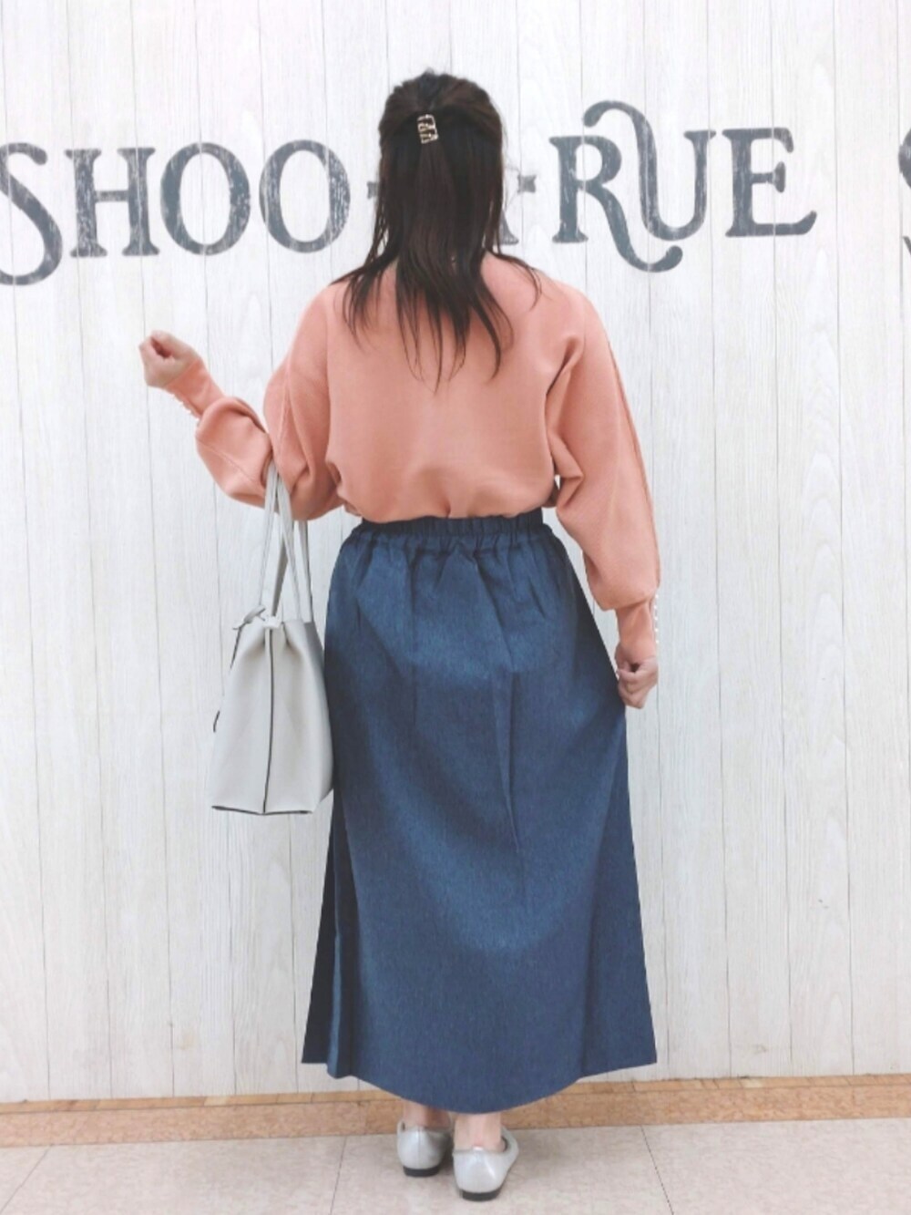 ピンク系のニット/セーター、ブルー系のスカート、グレー系のトートバッグを着用したレディースの秋コーディネートの3枚目の写真