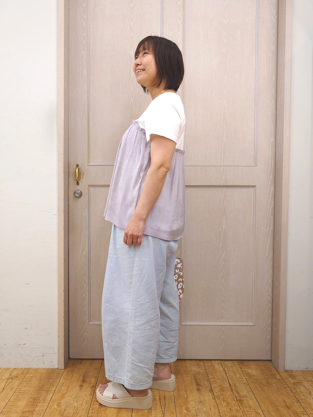 グレー系のTシャツ/カットソー、ブルー系のデニムパンツ、ベージュ系のサンダルを着用したレディースの夏コーディネートの2枚目の写真