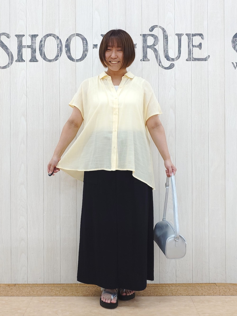 イエロー系のシャツ/ブラウス、ホワイト系のタンクトップ、ブラック系のスカートを着用したレディースの夏コーディネートの4枚目の写真