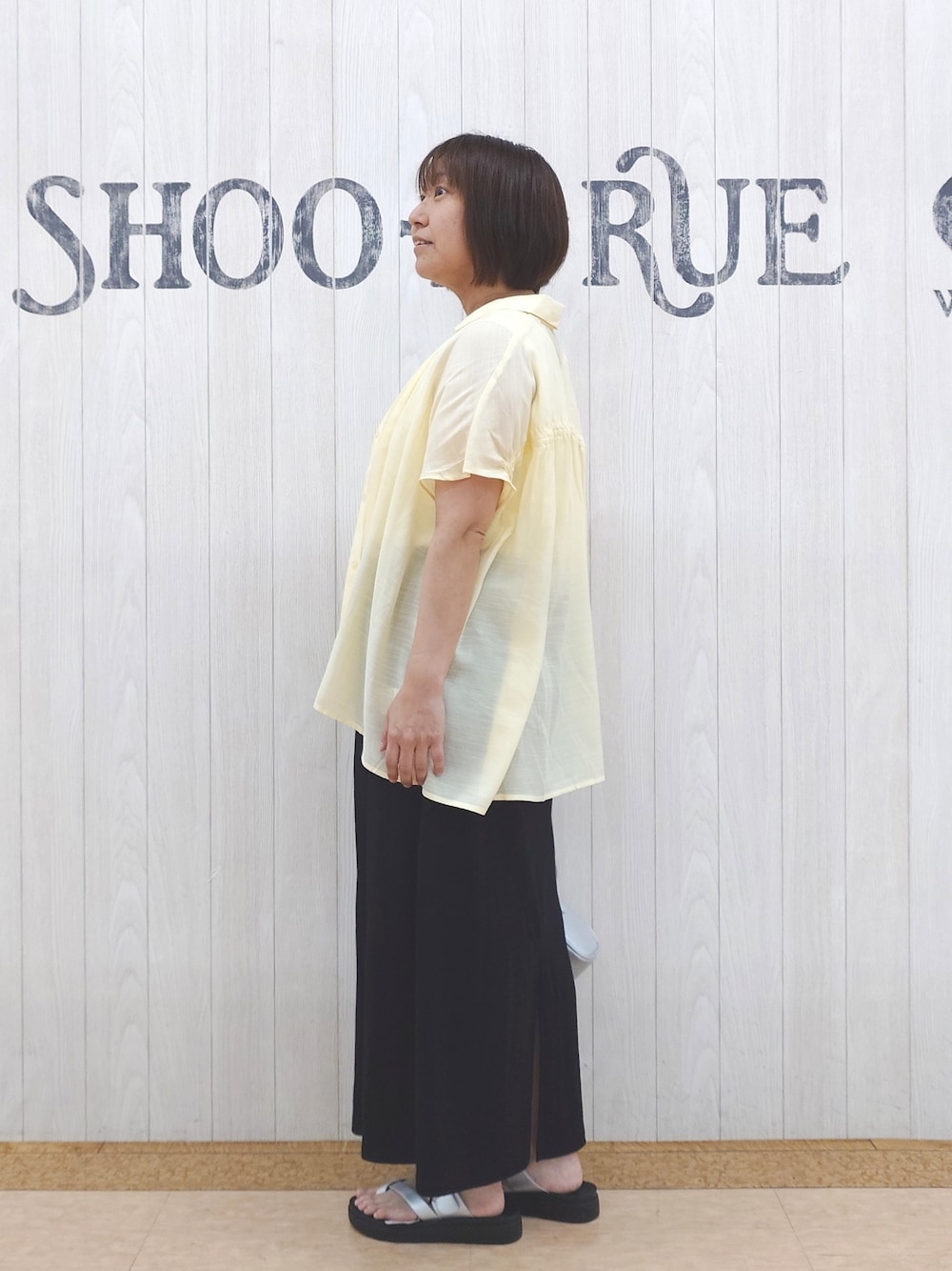 イエロー系のシャツ/ブラウス、ホワイト系のタンクトップ、ブラック系のスカートを着用したレディースの夏コーディネートの2枚目の写真