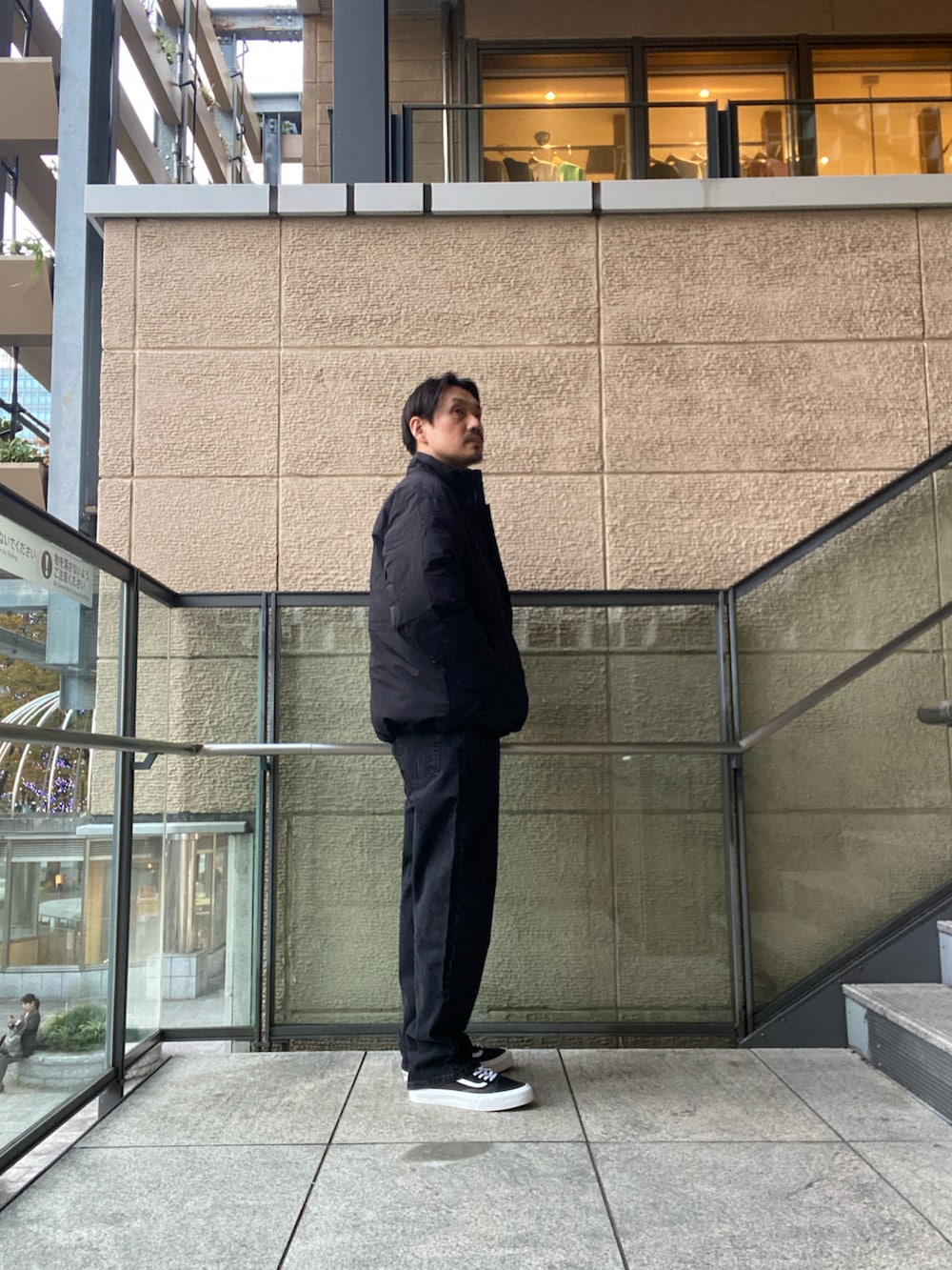 ブラック系のデニムパンツ、ブラック系のスニーカー、ブラック系のその他アウターを着用したメンズの秋コーディネートの4枚目の写真