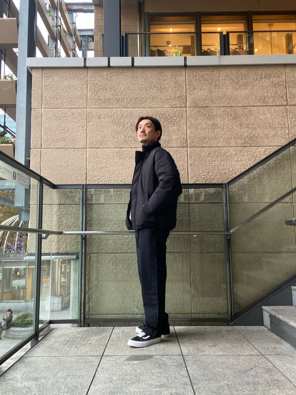 ブラック系のデニムパンツ、ブラック系のスニーカー、ブラック系のその他アウターを着用したメンズの秋コーディネートの2枚目の写真
