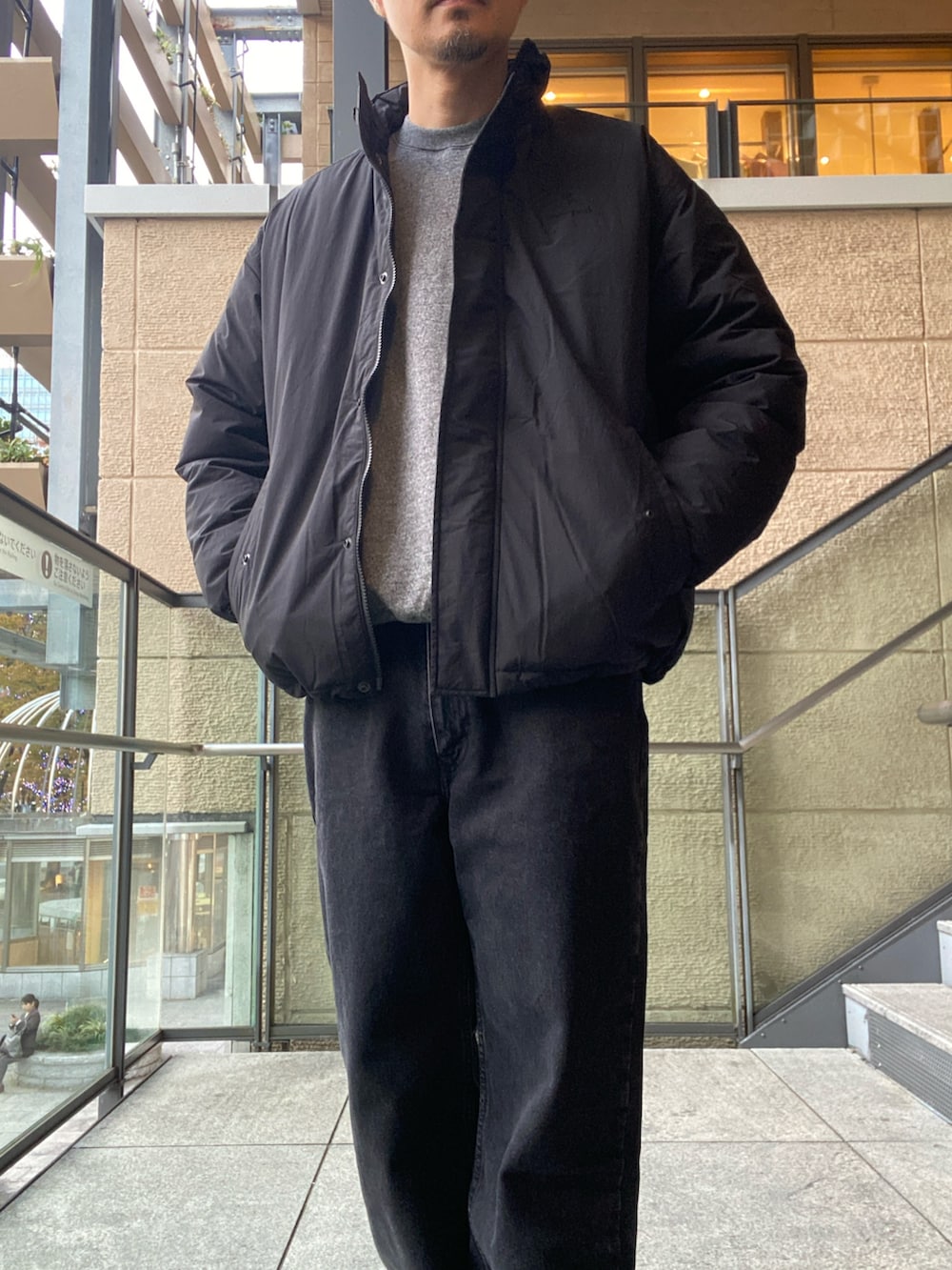 ブラック系のデニムパンツ、ブラック系のスニーカー、ブラック系のその他アウターを着用したメンズの秋コーディネートの6枚目の写真