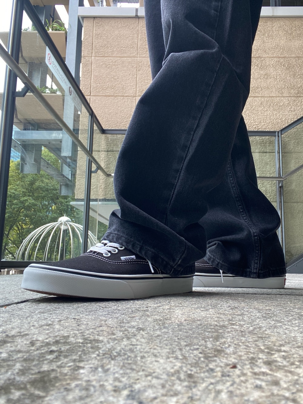 ブラック系のナイロンジャケット、ホワイト系のTシャツ/カットソー、ブラック系のデニムパンツを着用したメンズの秋コーディネートの7枚目の写真