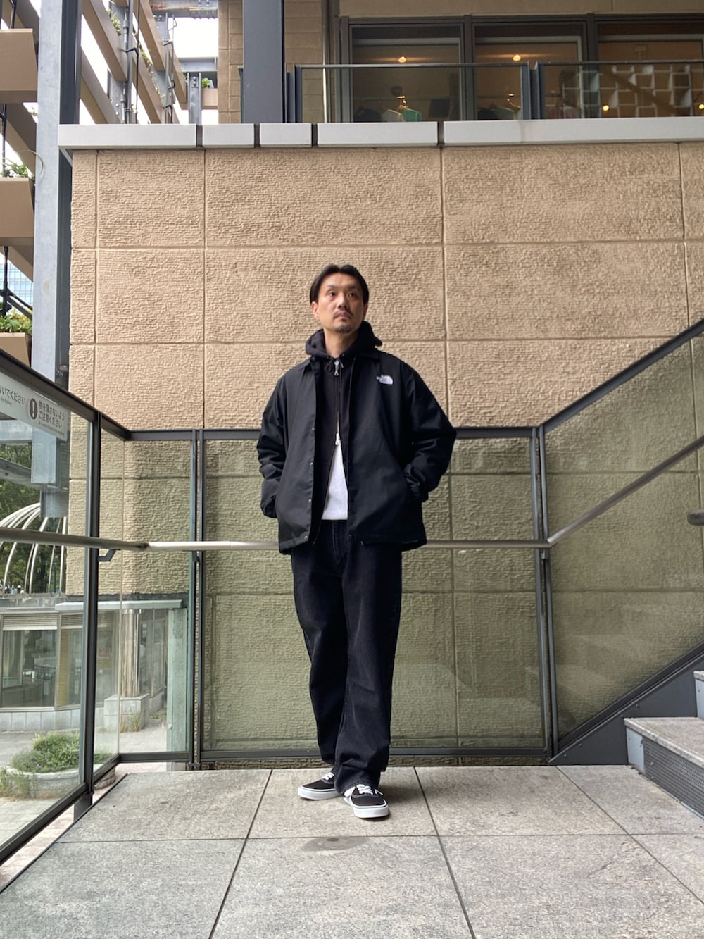 ブラック系のナイロンジャケット、ホワイト系のTシャツ/カットソー、ブラック系のデニムパンツを着用したメンズの秋コーディネートの3枚目の写真