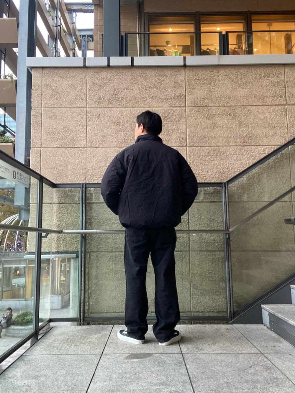 ブラック系のデニムパンツ、ブラック系のスニーカー、ブラック系のその他アウターを着用したメンズの秋コーディネートの3枚目の写真