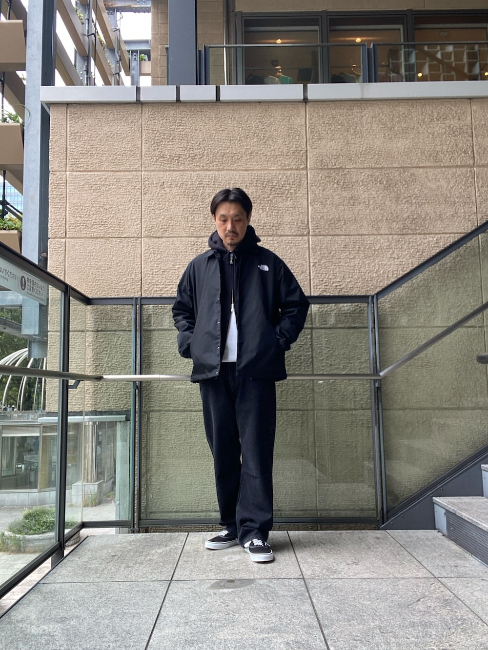 ブラック系のナイロンジャケット、ホワイト系のTシャツ/カットソー、ブラック系のデニムパンツを着用したメンズの秋コーディネートの4枚目の写真