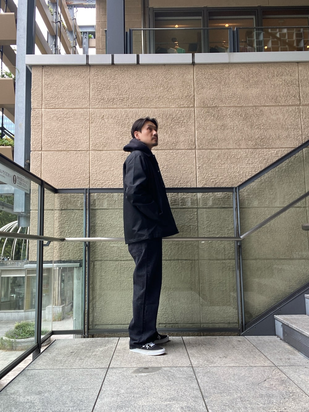 ブラック系のナイロンジャケット、ホワイト系のTシャツ/カットソー、ブラック系のデニムパンツを着用したメンズの秋コーディネートの2枚目の写真