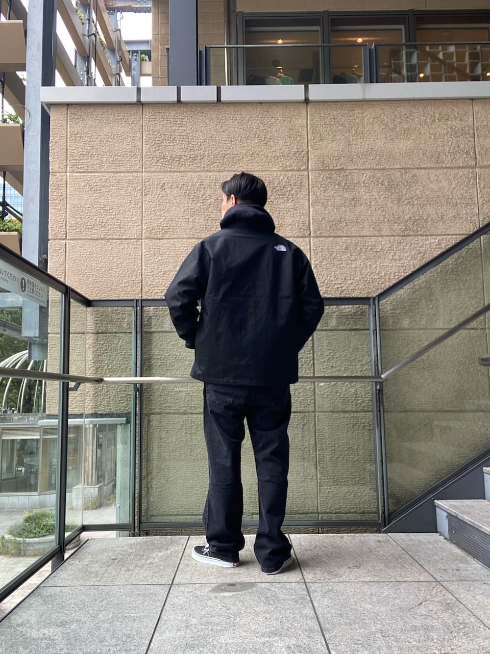 ブラック系のナイロンジャケット、ホワイト系のTシャツ/カットソー、ブラック系のデニムパンツを着用したメンズの秋コーディネートの5枚目の写真