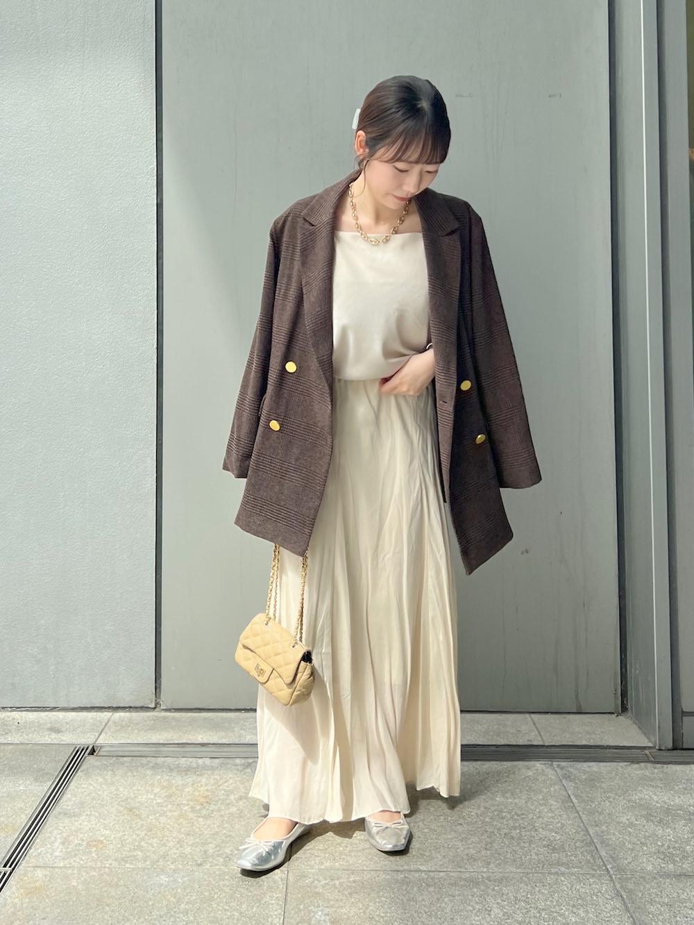 ブラウン系のテーラードジャケット、ホワイト系のスカート、ベージュ系のショルダーバッグを着用したレディースの秋コーディネートの3枚目の写真