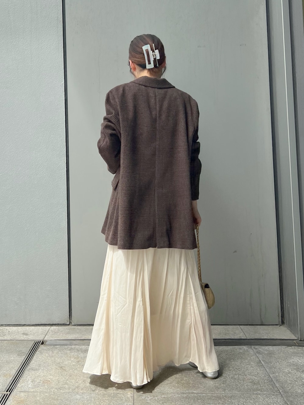 ブラウン系のテーラードジャケット、ホワイト系のスカート、ベージュ系のショルダーバッグを着用したレディースの秋コーディネートの5枚目の写真