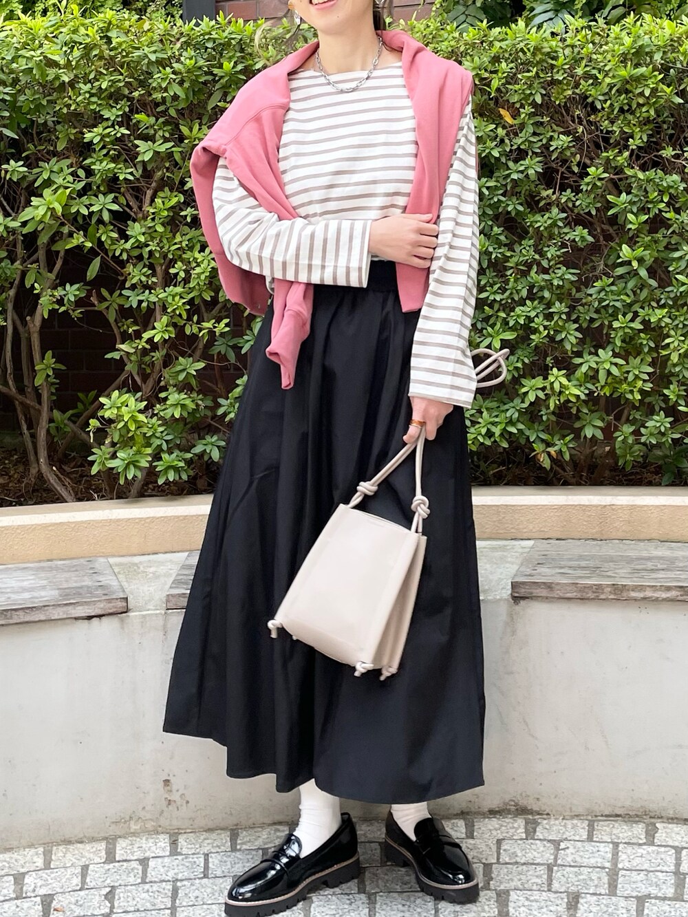 ピンク系のカーディガン/ボレロ、ベージュ系のTシャツ/カットソー、ベージュ系のショルダーバッグを着用したレディースの春コーディネートの2枚目の写真