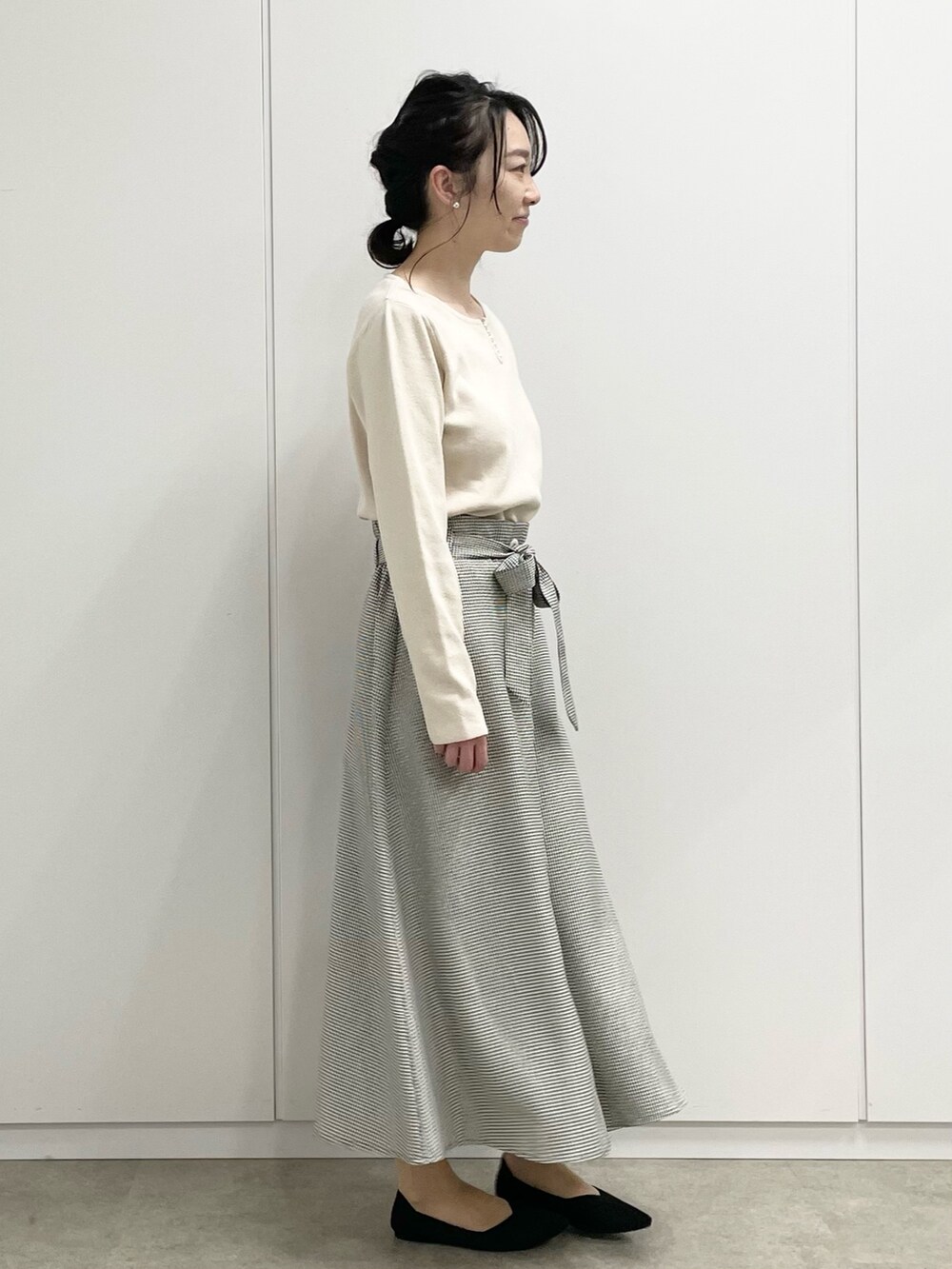 ブラウン系のスカート、グレー系のショルダーバッグ、ブラック系のパンプスを着用したレディースの冬コーディネートの2枚目の写真