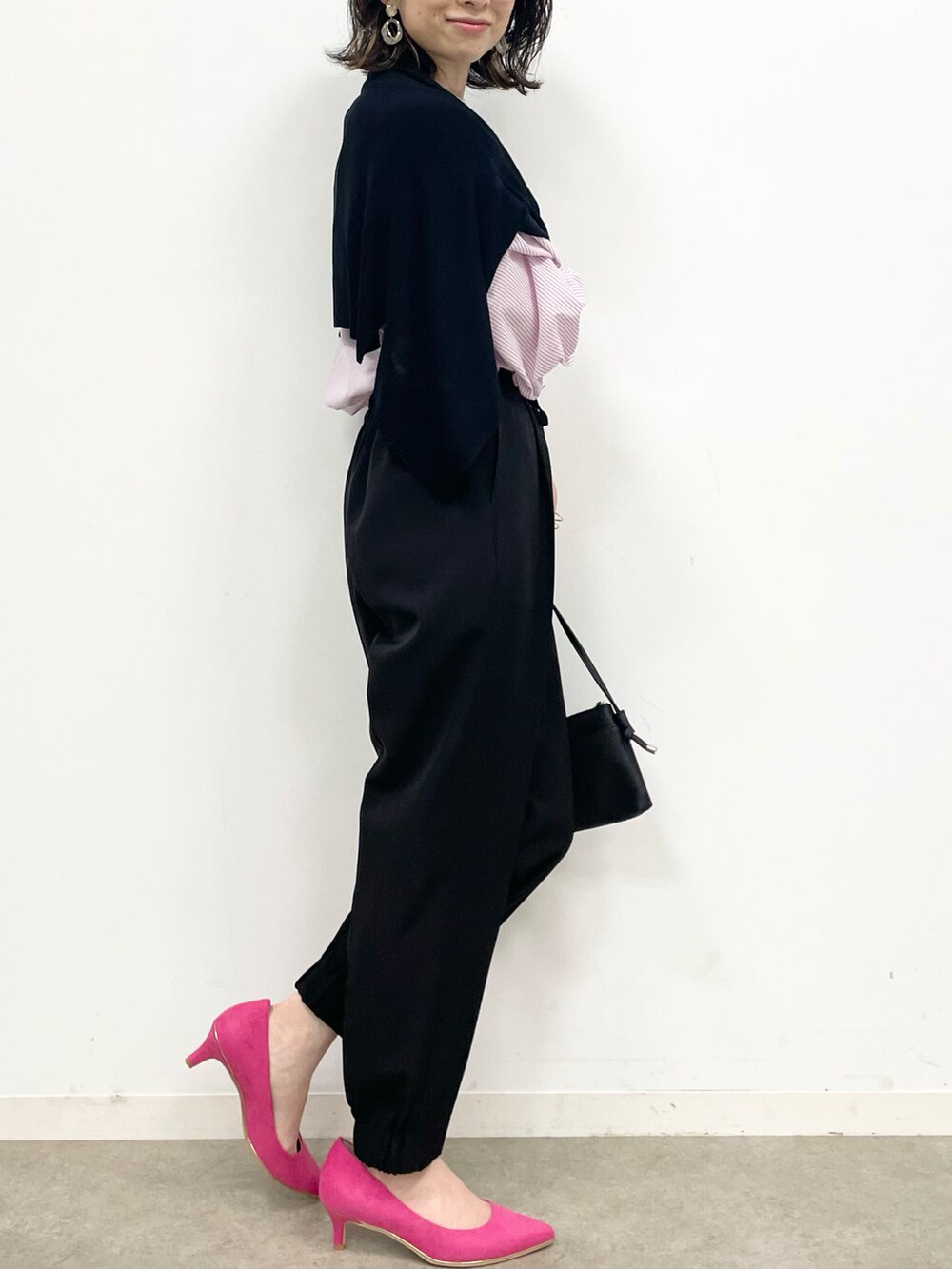 ピンク系のパンプス、ブラック系のその他パンツ、ブラック系のショルダーバッグを着用したレディースの春コーディネートの3枚目の写真