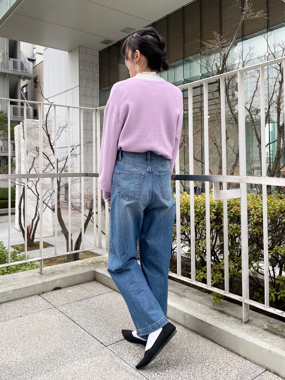 ブルー系のデニムパンツ、ブラック系のパンプス、パープル系のカーディガン/ボレロを着用したレディースの冬コーディネートの3枚目の写真