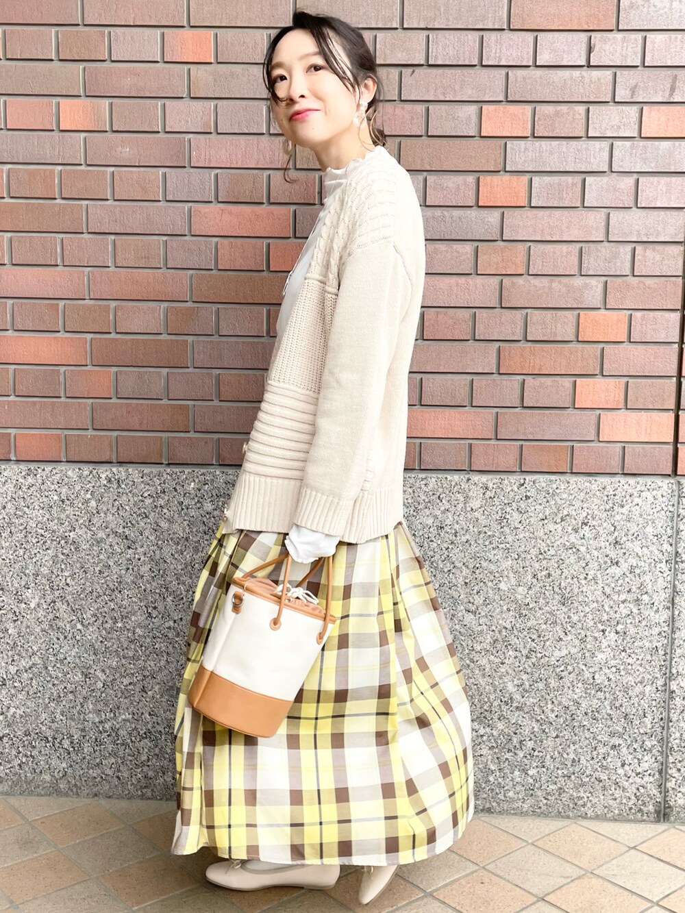 ホワイト系のTシャツ/カットソー、ホワイト系のカーディガン/ボレロ、イエロー系のスカートを着用したレディースの春コーディネートの2枚目の写真