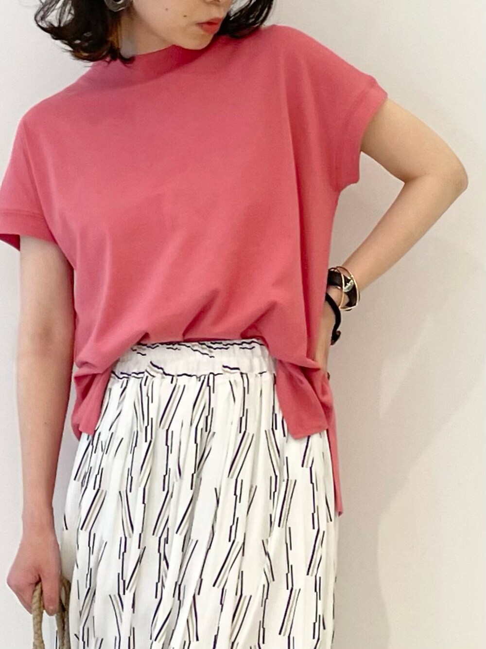 ホワイト系のスカート、ピンク系のTシャツ/カットソー、ベージュ系のサンダルを着用したレディースの春コーディネートの2枚目の写真