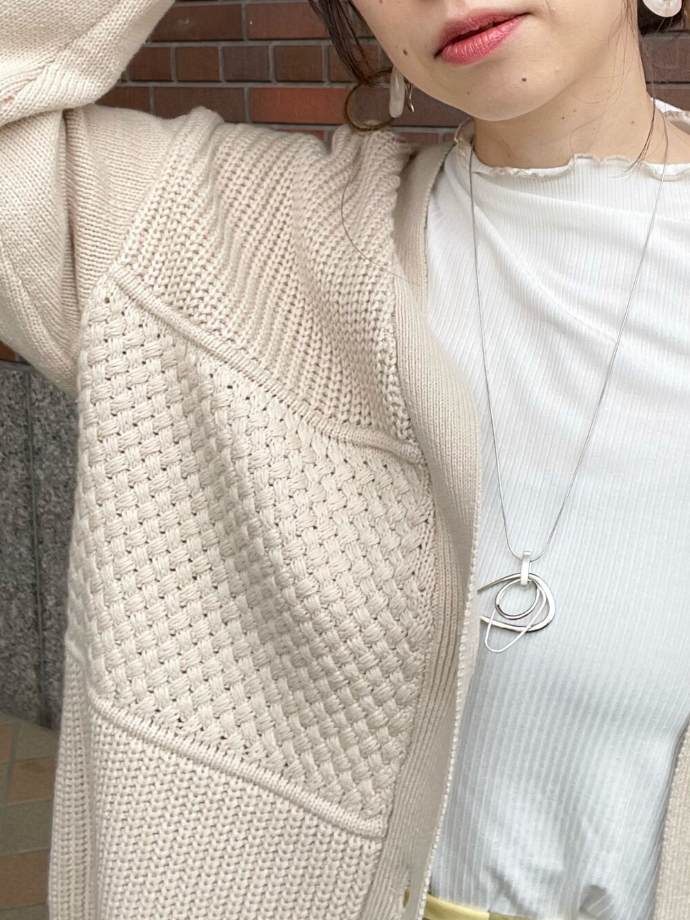 ホワイト系のTシャツ/カットソー、ホワイト系のカーディガン/ボレロ、イエロー系のスカートを着用したレディースの春コーディネートの4枚目の写真