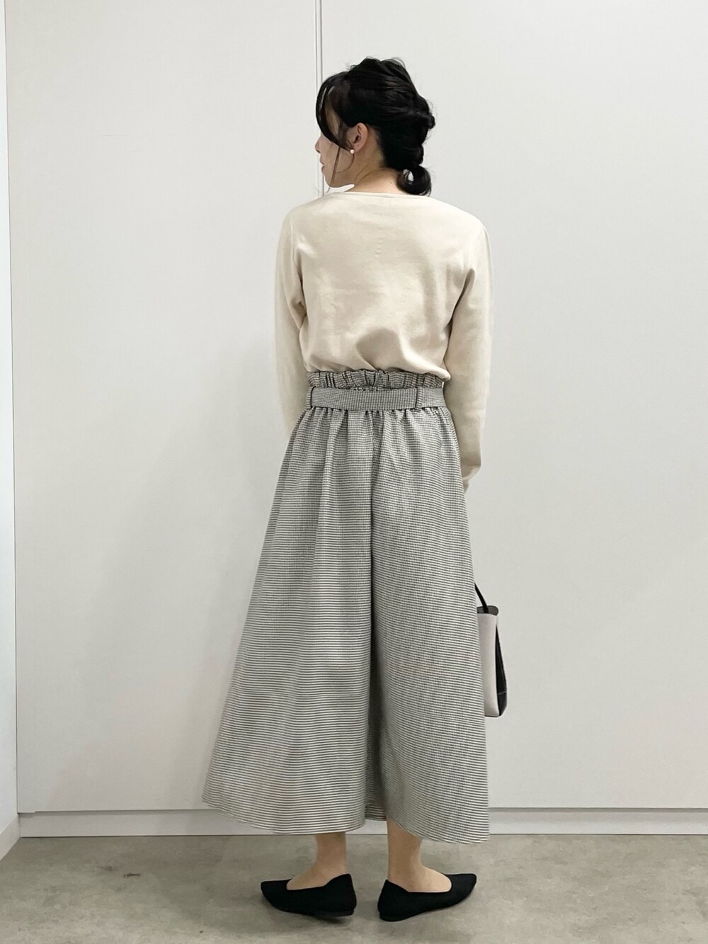 ブラウン系のスカート、グレー系のショルダーバッグ、ブラック系のパンプスを着用したレディースの冬コーディネートの3枚目の写真