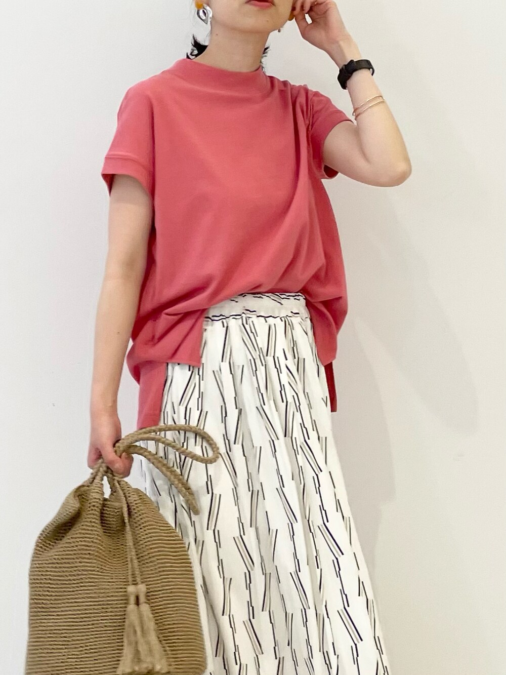 ホワイト系のスカート、ピンク系のTシャツ/カットソー、ベージュ系のサンダルを着用したレディースの春コーディネートの4枚目の写真