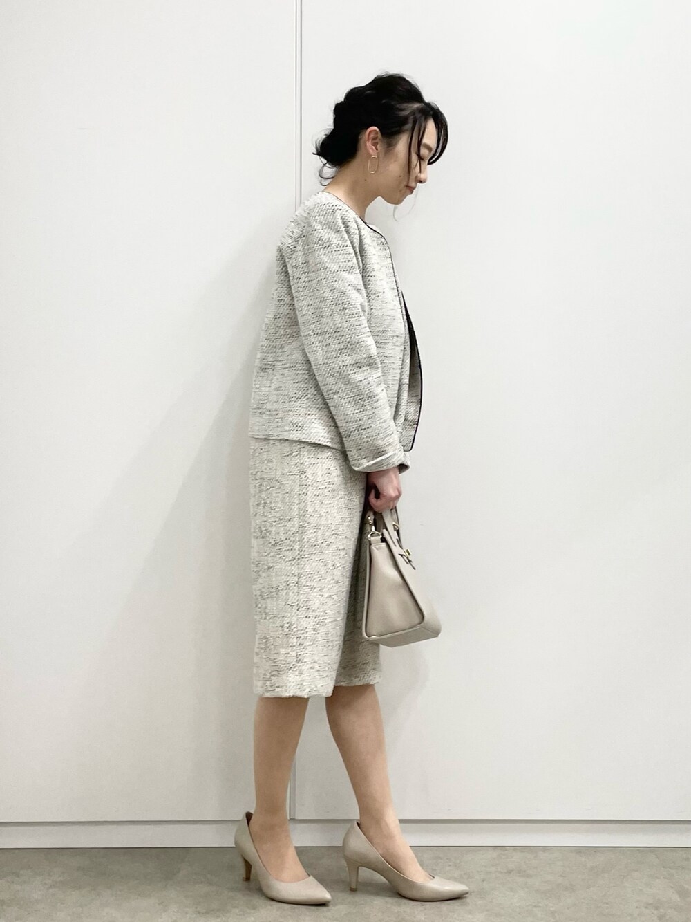 グレー系のワンピース、グレー系のノーカラージャケット、グレー系のトートバッグを着用したレディースの冬コーディネートの2枚目の写真