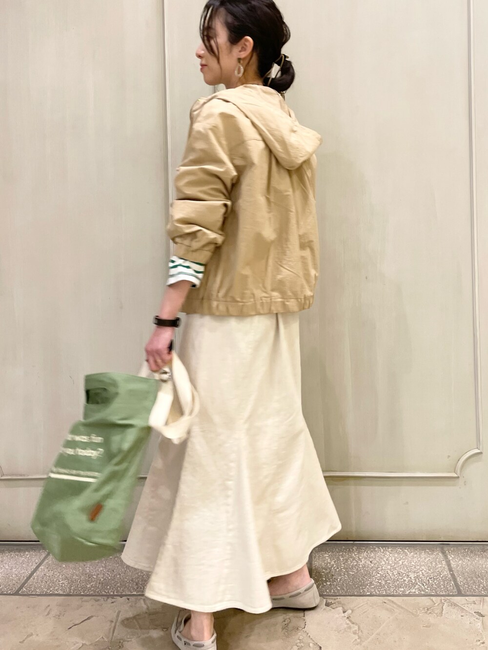 グリーン系のショルダーバッグ、ホワイト系のデニムスカート、グリーン系のTシャツ/カットソーを着用したレディースの春コーディネートの3枚目の写真