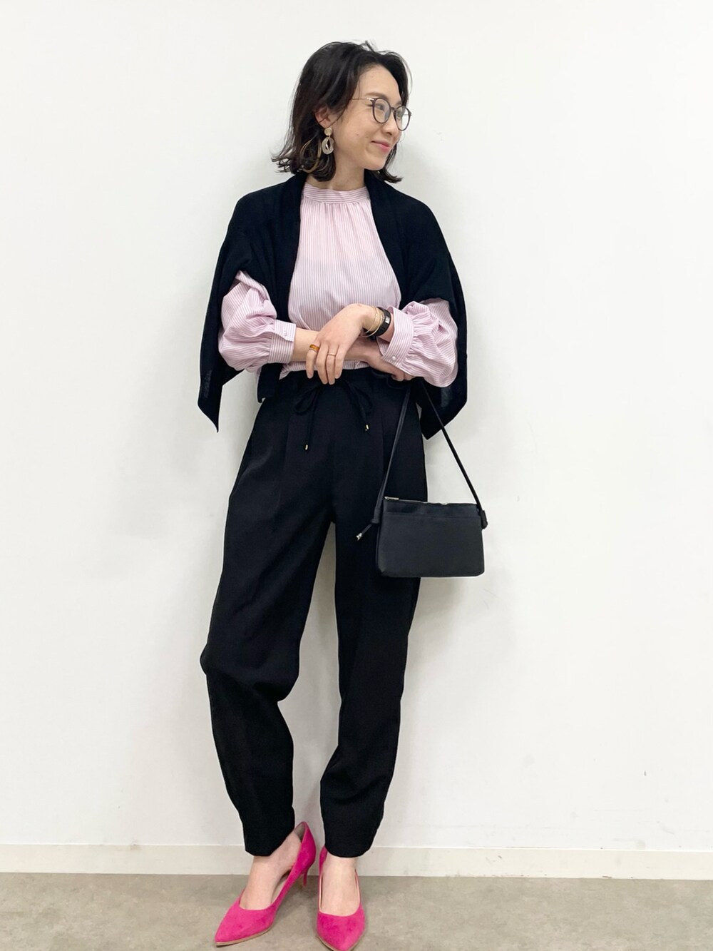 ピンク系のパンプス、ブラック系のその他パンツ、ブラック系のショルダーバッグを着用したレディースの春コーディネートの2枚目の写真