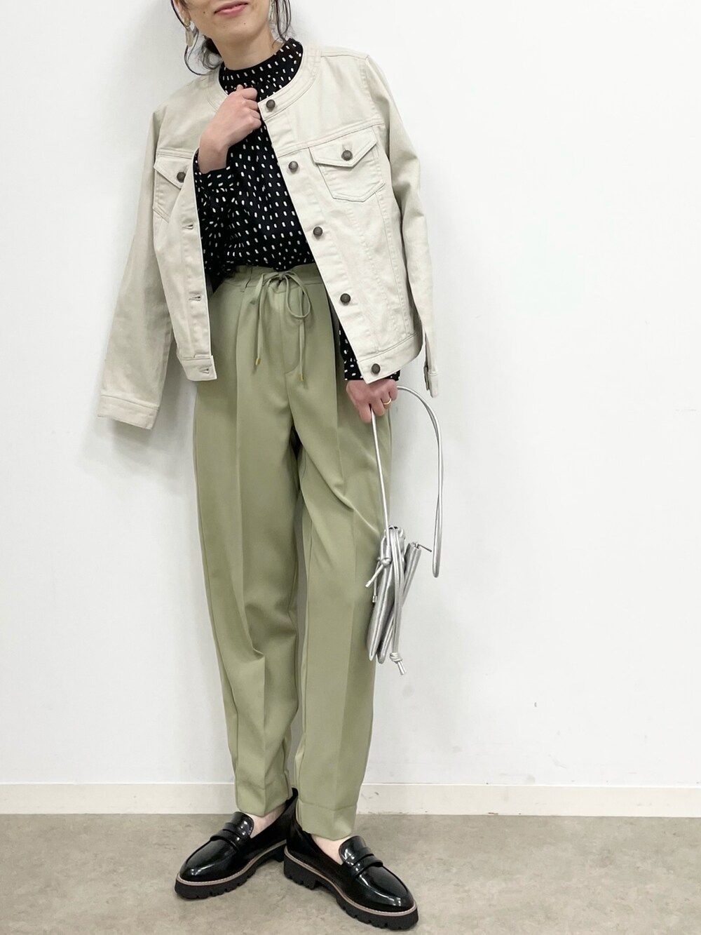 グレー系のデニムジャケット、グリーン系のその他パンツ、シルバー系のショルダーバッグを着用したレディースの春コーディネートの3枚目の写真