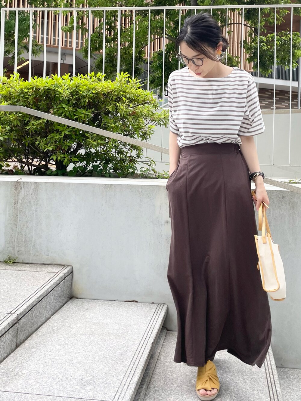 ブラウン系のTシャツ/カットソー、ブラウン系のスカート、イエロー系のサンダルを着用したレディースの夏コーディネートの3枚目の写真