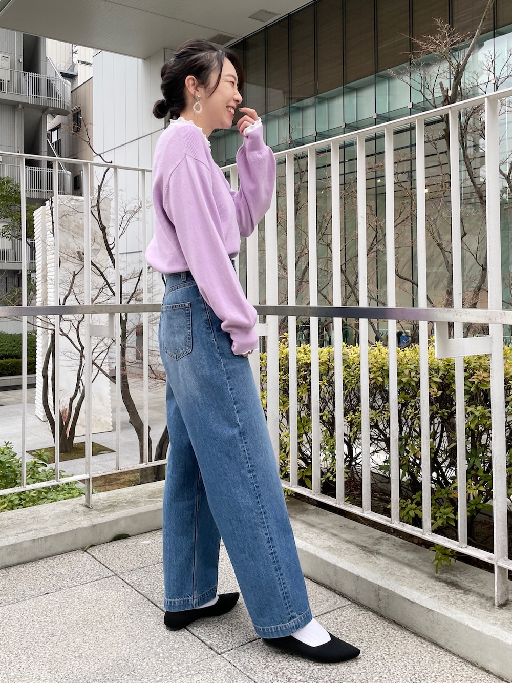 ブルー系のデニムパンツ、ブラック系のパンプス、パープル系のカーディガン/ボレロを着用したレディースの冬コーディネートの2枚目の写真