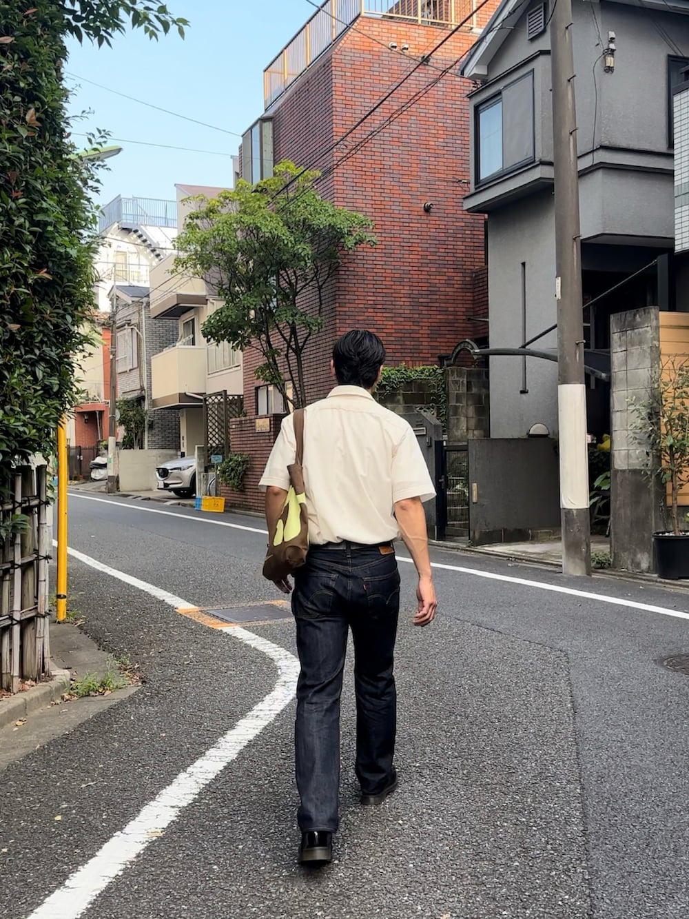 ブルー系のデニムパンツ、ブラック系のローファーを着用したメンズの秋コーディネートの3枚目の写真