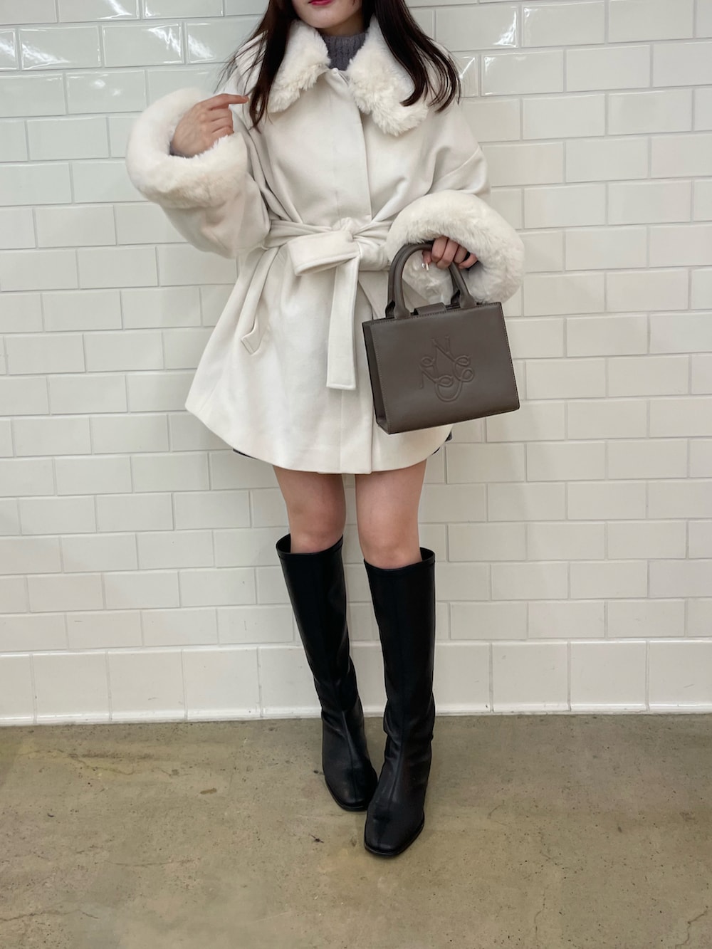 ホワイト系のその他アウター、ブラック系のトートバッグを着用したレディースの秋コーディネートの3枚目の写真