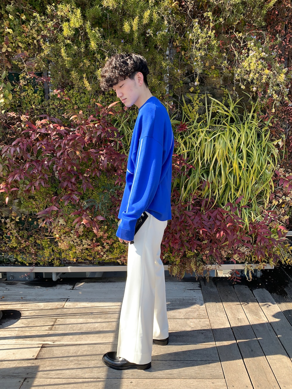 ホワイト系のスラックス、ブルー系のニット/セーターを着用したメンズの冬コーディネートの2枚目の写真