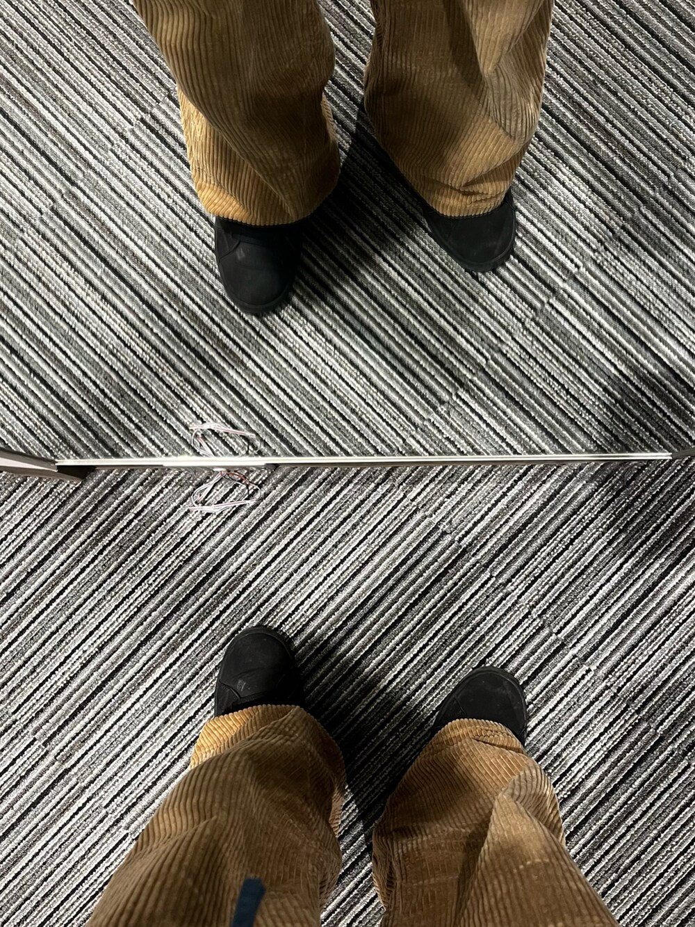 ブラウン系のパンツ、ブラック系のスニーカー、ブラック系のショルダーバッグを着用したメンズの春コーディネートの5枚目の写真